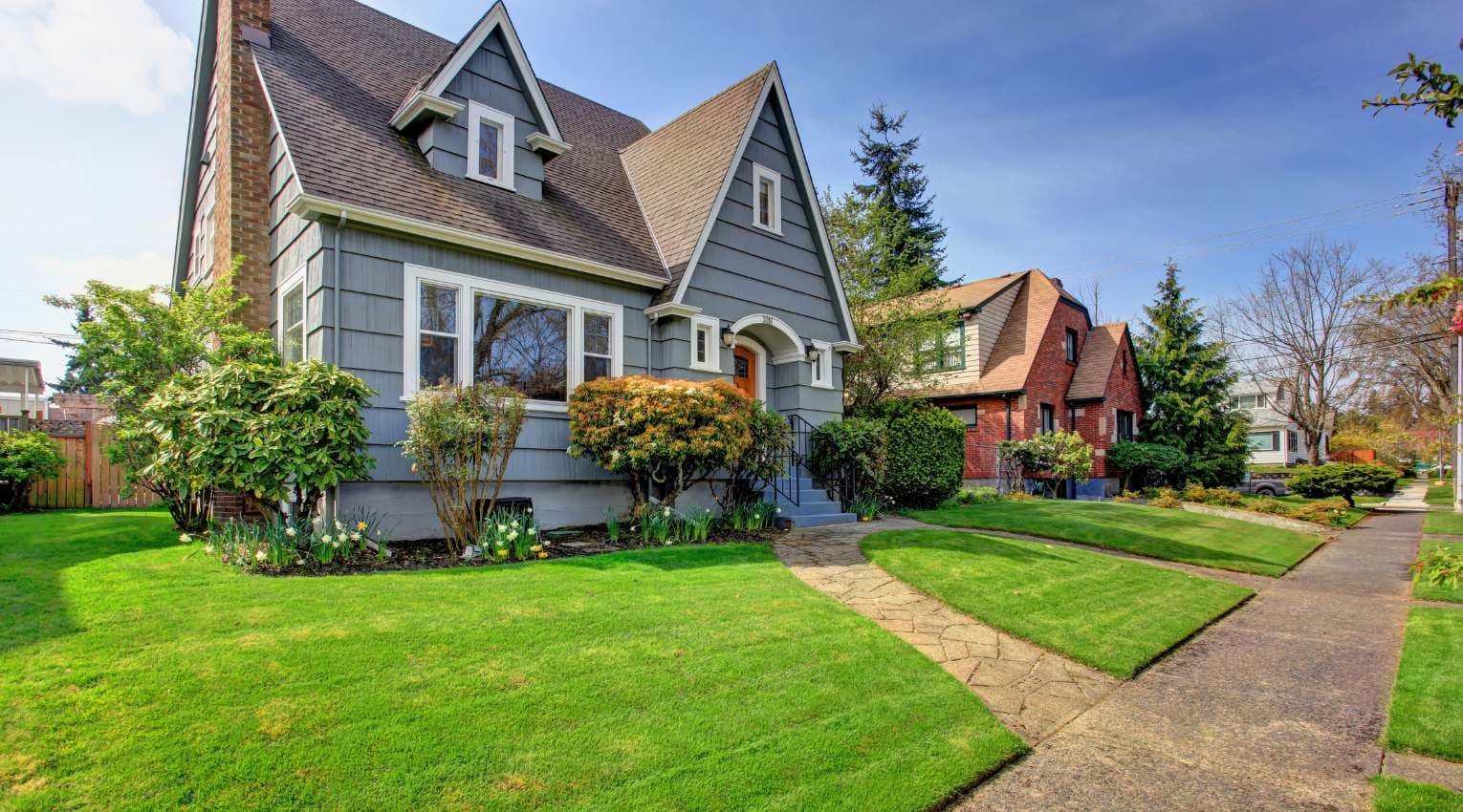 suburban blue home with green lawn